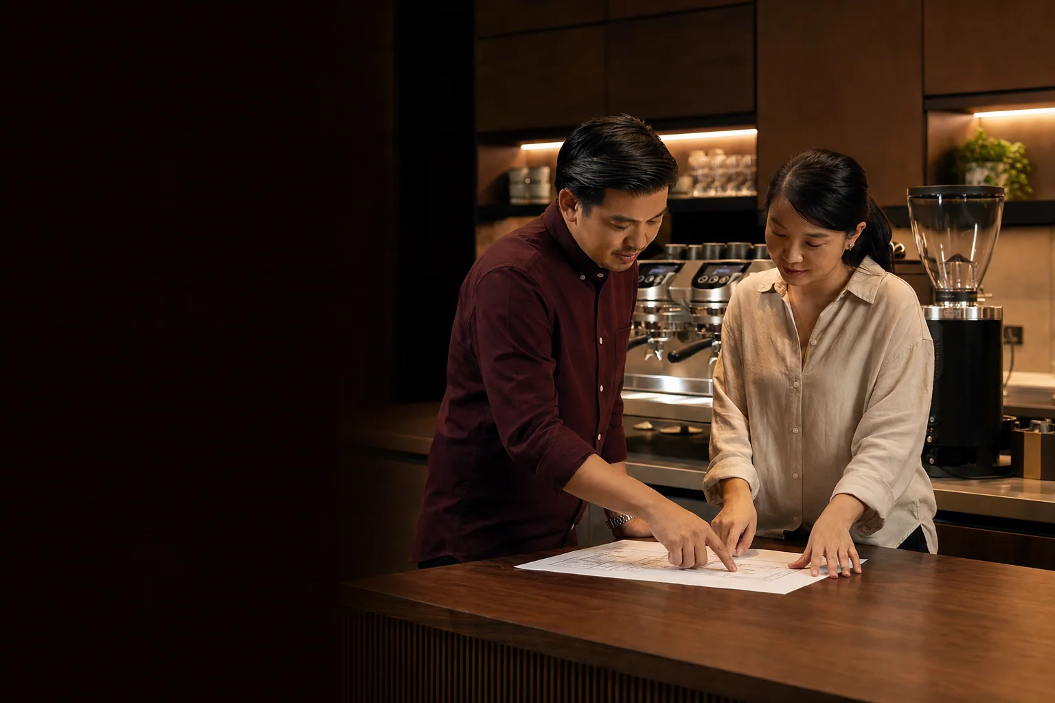 ที่ปรึกษากาแฟและเจ้าของคาเฟ่กำลังดูแผนเคาน์เตอร์ข้างเครื่องชงกาแฟ